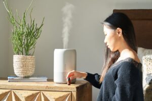 woman using air purifier at home
